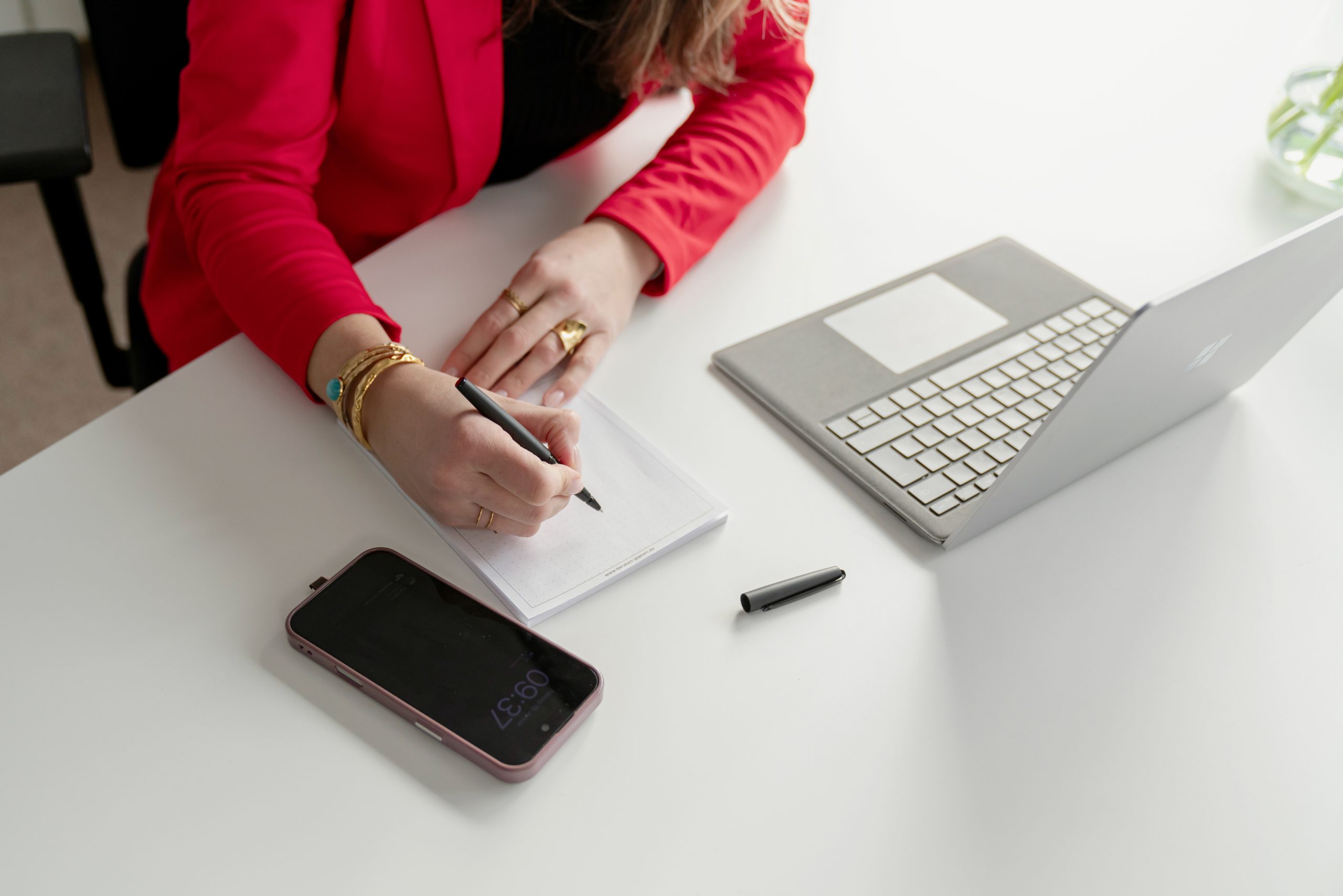 Immobilienmaklerin aus Burglengenfeld macht sich Notizen zur immobilienbewertung und Immobilienberatung am Schreibtisch bei ImmoDC GmbH